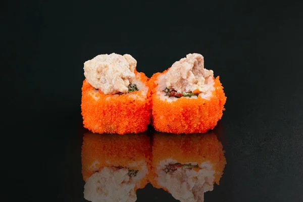 sushi rolls with fish and white rice with cream cheese on black table background