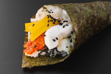 Somonlu suşi ve siyah tabakta avokado.