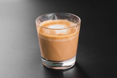 Masada buz küpleri olan bir bardak soğuk içecek.