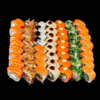 Kırmızı somon balığı, beyaz pirinç ve siyah arka planda izole edilmiş krem peynirli bir sürü farklı suşi rulosu.