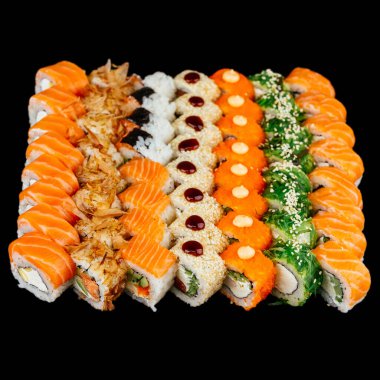 Kırmızı somon balığı, beyaz pirinç ve siyah arka planda izole edilmiş krem peynirli bir sürü farklı suşi rulosu.