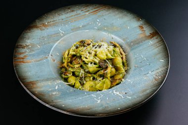 mantarlı makarna ve tabakta peynir, siyah arka planda