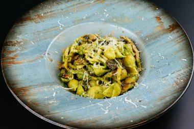 mantarlı makarna ve tabakta peynir, siyah arka planda