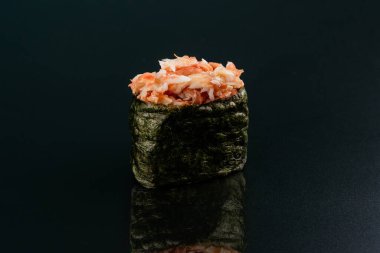 Somonlu suşi ve siyah arka planda avokado.