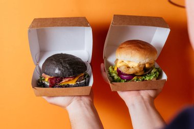 Hamburgerle sandviç tutan bir kadın, fast food.