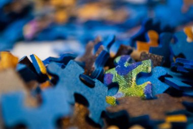 Yapbozun renkli parçalarının yakın çekimi. Bulmaca Parçaları Yığını. Bulmaca parçaları. Bulmaca figürleri. Eğlence için bulmaca. 