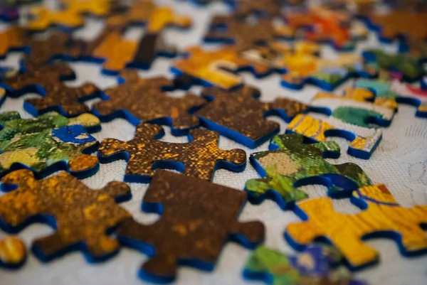 Close-up of colorful pieces of puzzle. Puzzle pieces sorted face up. Stack of Puzzle Pieces. Puzzle pieces. Puzzle figures. Puzzle for fun.