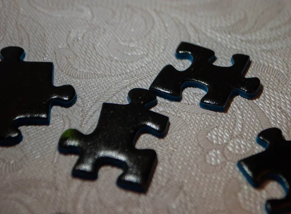 Egy Közeli Kép Fekete Darabokról Egy Halom Puzzle Darab Rejtvénydarabok — Stock Fotó