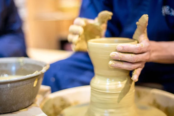 Hands with modeling of clay on a potter\'s wheel in the pottery workshop, Japan