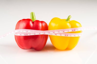 Beyaz arkaplanda mezura bulunan Paprikalar 