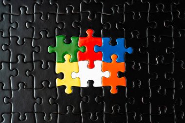 Siyahlarla çevrili renkli yapboz parçaları