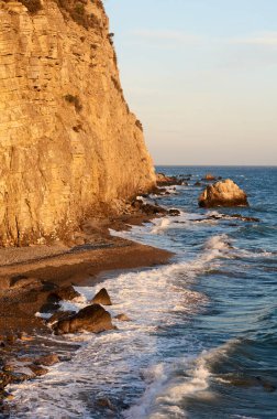 Sıcak ve güneşli bir günde kayalık bir sahil.