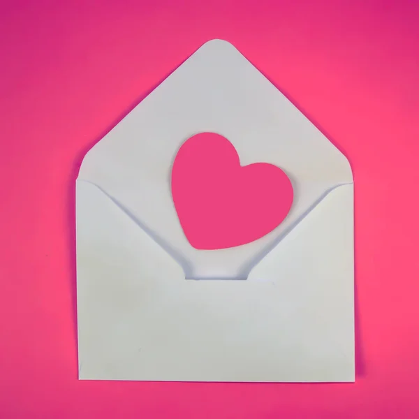 Beyaz bir zarfta pembe kalp.