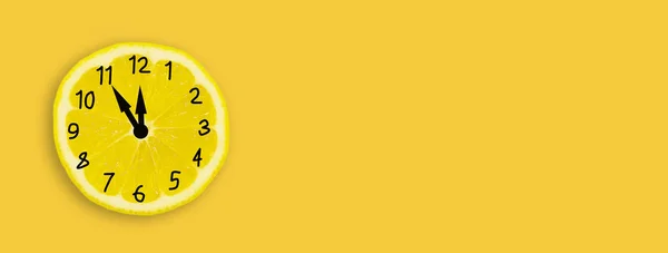 Limon kavramı. Sarı arka planda limon şeklinde bir saat. Pankart.