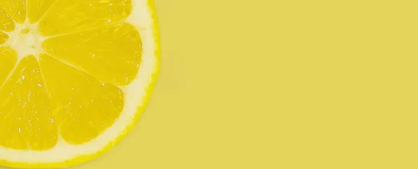 Frische Zitronenscheibe auf gelbem Hintergrund. Minimalistisches Banner. Stockbild