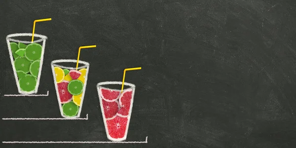 Slices of fruit in a glass on a black chalk board. Citrus smoothie. Banner.