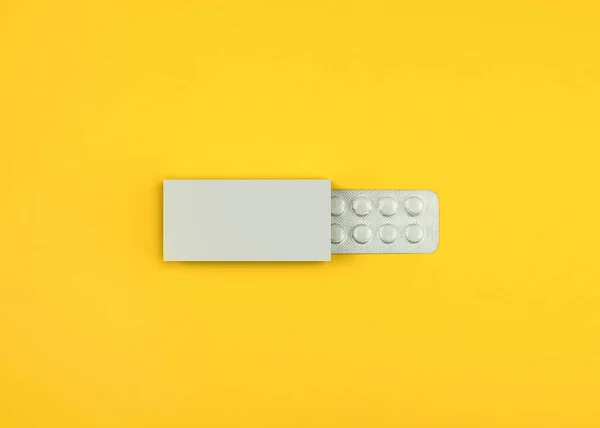 Pills in a box on a yellow background