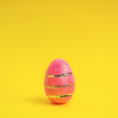 Sarı arka planda paskalya pembesi süslemeli yumurta. Asgari paskalya kavramı.