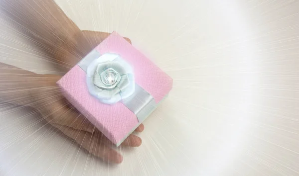 Bir çocuğun elinde hediye kutusu.