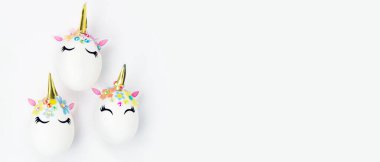 Paskalya tatili konsepti. Tek boynuzlu at şeklinde üç yumurta. Banner.