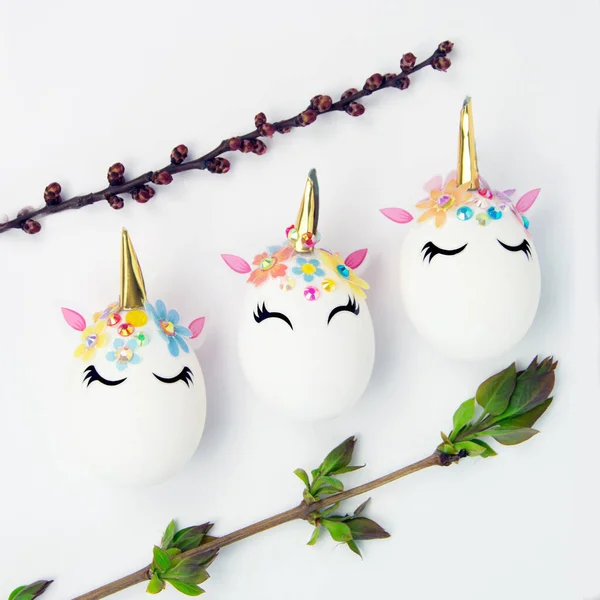 Paskalya konsepti. Tek boynuzlu atlar şekilli yumurtalar. Tomurcukları ve yaprakları olan dallar