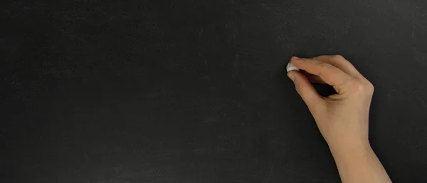 Kadın eli boş bir tebeşirle yazı yazmak üzere..