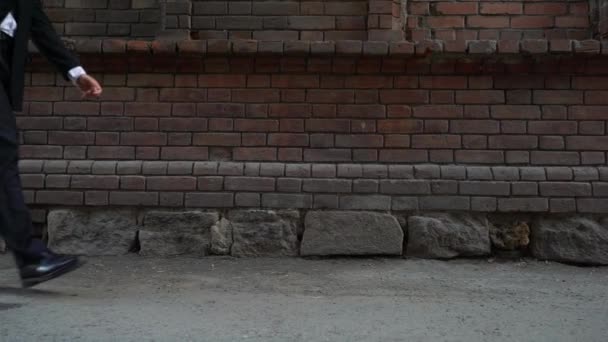 沿着一堵砖墙的商人 — 图库视频影像