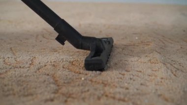 Halıyı temizleyen elektrikli süpürge. 