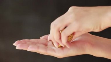 Arka planda renkli hapları tutan bir elin yakın plan çekimi.