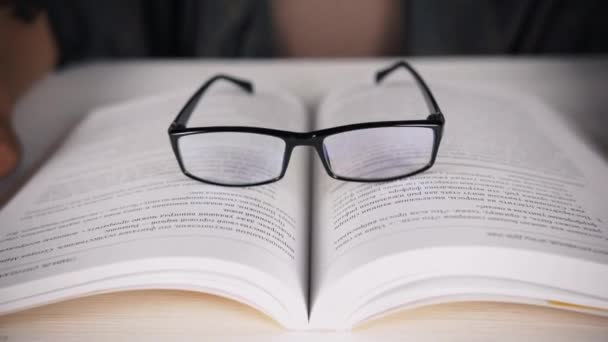 Meisje Zitten Aan Een Witte Tafel Met Bril Het Lezen — Stockvideo