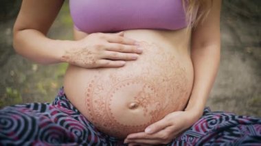 Kafkasyalı hamile kadın boho stili beyaz mehendi ile bebek için yeni çağ yaşam tarzı bilinçli ebeveyn kavramına bel beklentisinde.