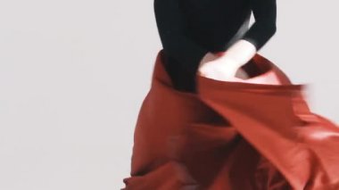 Kanat çırpan kırmızı etekli bir kadın poz veriyor kırmızı bir bez çırpınıyor 