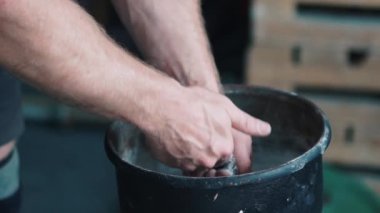 Güçlü sporcu ellerini magnezyumla ovalıyor. Toz çok yakın.
