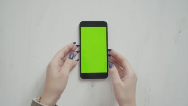 美しい女の子は緑の画面の緑の画面の手の中にスマートフォンを保持 — ストック動画
