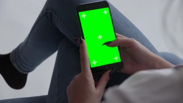 携帯電話を持っている男の緑の画面の手にスマートフォンを持っている美しい女の子白の背景にクロマキー緑の画面 — ストック動画