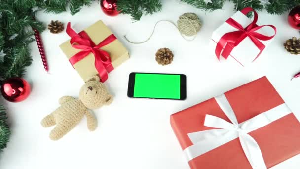 木制背景图黑色智能手机 绿色屏幕 桌上摆放着圣诞装饰品 — 图库视频影像