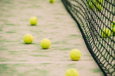 Net of outdoor green paddle court,side view, with balls around with copy space. Sports concept