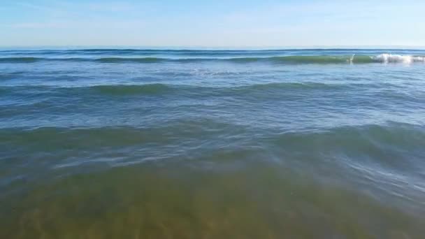 COMING OUT OF THE SEA WITH SMALL WAVES ON A SUNNY DAY — Stockvideo