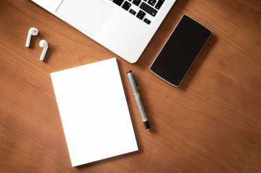 Bilgisayarlı ahşap ofis masası, akıllı telefon ve metni girmek için boş defter sayfası. İş ve Teknoloji Konsepti