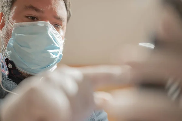 View from below of a man wearing a flu mask looking at his mobile phone with a very serious expression.Focus selective.Copy space.Pandemic,Covid 19 and technology concept