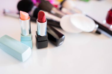 Kozmetik ürünlerin yanında farklı renklerde ruj. Kadınsı güzellik ve kişisel imaj bakımı kavramı.