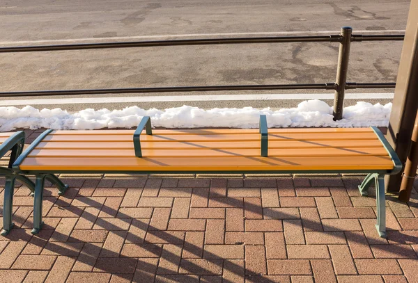 Empty wooden bench at bus stop in winter — Stock Photo, Image