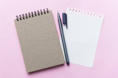 defter ve kalem pastel arka plan üzerinde