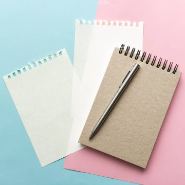 defter ve kalem pastel arka plan üzerinde