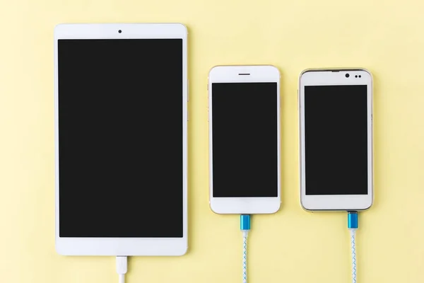 Зарядка кабелей со смартфоном и планшетом в виде сверху — стоковое фото