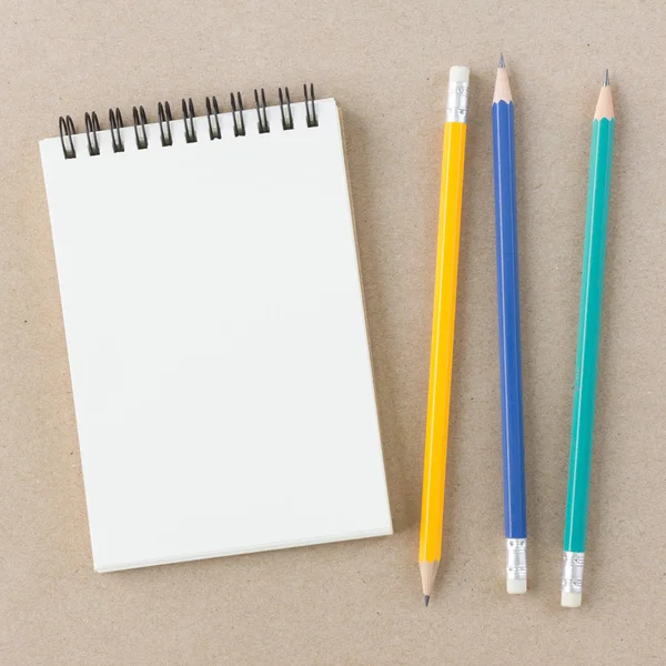 Leeres Notizbuch und Bleistift auf braunem Hintergrund in der Draufsicht — Stockfoto