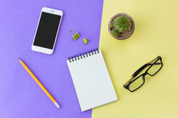 Office supplies on yellow and purple in top view — Stock Photo, Image