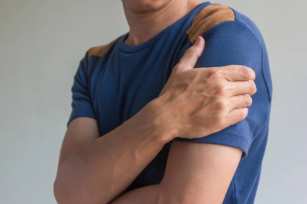 Молодой человек с болью в плече — стоковое фото