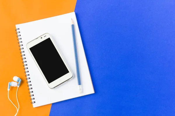 Kopfhörer Smartphone und Notebook in Draufsicht auf blau und orange — Stockfoto