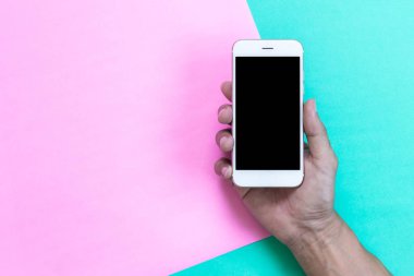 adam el smartphone top pembe ve yeşil zemin üzerine tutarak 